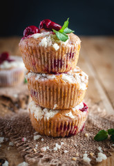 Close-up of cherry muffins with crumbly topping on wooden background 