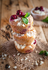 Close-up of cherry muffins with crumbly topping on wooden background 