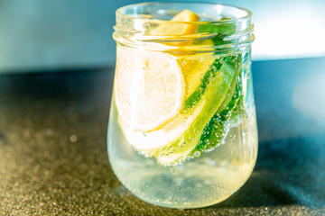 Summer drink coctail in glass jar, berries and mint on wooden table