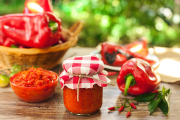 Homemade ajvar in glass jar on table
