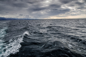 Waves on surface of water with cloudy sky