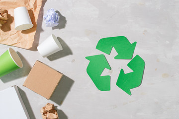 recycling symbol with waste on wooden background top view