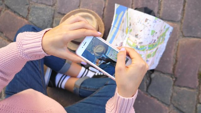 Young Female Tourist Taking Photo Of Feet, Map, Camera And Hat With Cell Phone