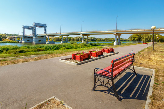 The bridge above the river and the bench on the park alley. Don river, Russia, Rostov-on-Don region, stanitsa Kazanskaya