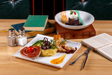 Set of Irish corned beef with crispy crust, venison sausage, grilled fillet of young chicken, red onion stuffed with beef and beer cake made of chocolate biscuit and walnut.