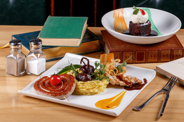 Set of Irish corned beef with crispy crust, venison sausage, grilled fillet of young chicken, red onion stuffed with beef and beer cake made of chocolate biscuit and walnut.