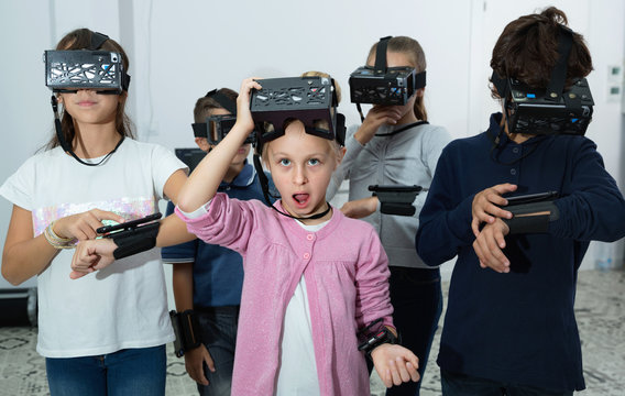 Enthusiastic children in virtual reality glasses in quest room