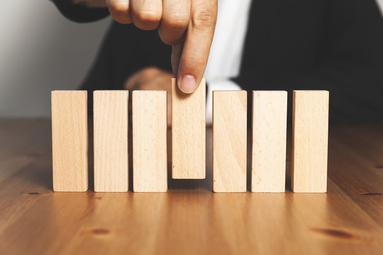 Businessman Hand Arranging Or Picking Red Wood Block