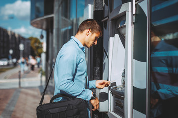 Young businessman withdraws money from the ATM