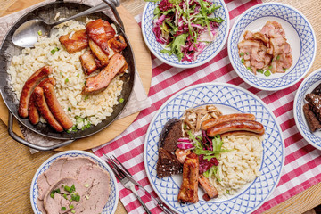 Oktoberfest food menu: sausages, fried bacon, pork ears, salad.