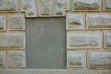 gray bricked concrete old window on a stone wall