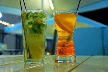 mojito and cocktail in two long glass glasses on the table