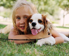 7 year old girl is walking with a puppy in the park