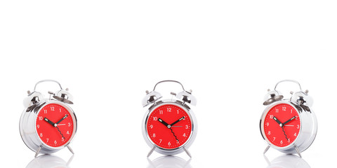 GROUP OF RED CLOCKS ON WHITE BACKGROUND.