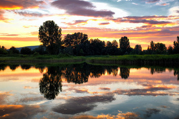 Picturesque sunset over a lake with reflections and colorful cloudscape