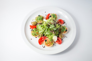 Fresh salad with salmon, olives, green, tomatoes and quail eggs