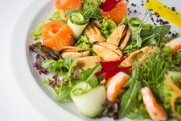 Seafood fresh salad with shrimps, mussels, salmon, green and cucumber