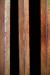 close up view of rust fence with black background behind