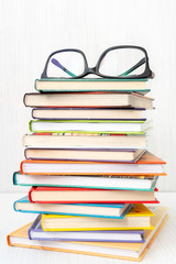 Stack of books with a eyeglasses on top