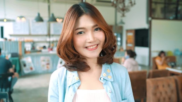 Portrait of Beautiful young asian brunette woman smiling while standing in cafe. Women lifestyle concept.