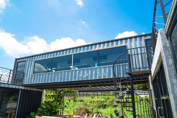 Modern metal building made from shipping house containers and blue sky background .