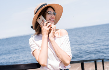 Young pretty traveler woman calling and talking phone, wifi conection on sunny beach, travel alone with backpack at hot tropical country, casual outfit, trip tour agensy, adventure mood.