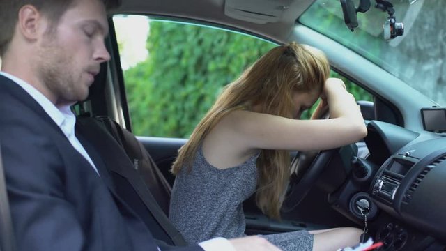 Sad woman failed driving license exam, unhappy instructor writing documents