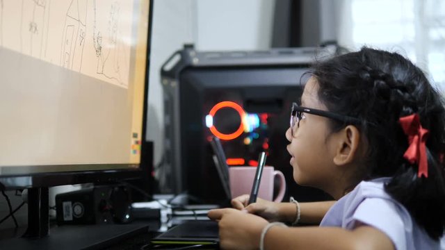 Asian little girl in Thai student uniform using pen tablet to drawing and digital painting with computer