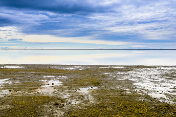 Beautiful isolated green colored Iceland lake with blue skies and puffy clouds. Reflection on water.
