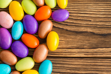 Brightly colored sugar coated almonds on wood