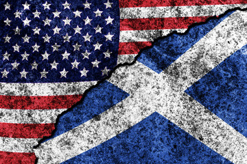 two flags of the USA and Scotland on a cracked concrete wall