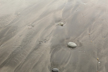 Black sand mixed with yellow sand with some grey rocks in the Almaciga beach in Tenerife, Canary island