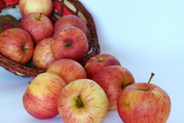 Apples falling out of the basket on white background.