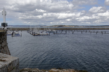 Fototapeta premium The piers of La Coruña marina sea port with many sailing boats and a blue sky with some clouds
