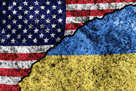 two flags of the USA and Ukraine on a cracked concrete wall