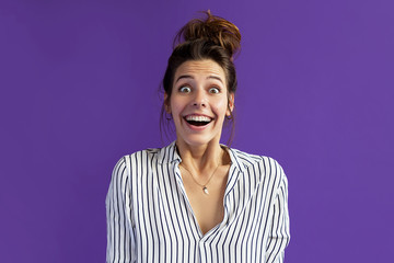 Wow! Unexpected news and a bright emotion, a woman on a violet background learned something unexpected and pleasant, she was surprised, delighted and joyful anticipation