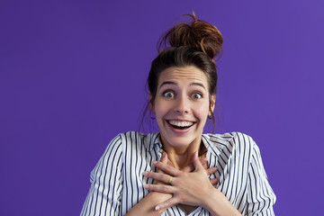 Wow! Unexpected news and a bright emotion, a woman on a violet background learned something...