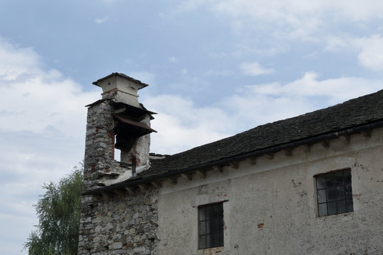 The stone bell tower of the church of the cemetery of the Orta San Giulio town on the Lake Orta in the province of Novara, Northern Italy