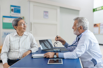 The elderly patient man talking with senior doctor