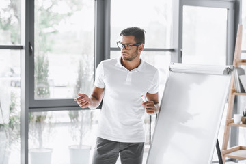 concentrated businessman making presentation at white board in office