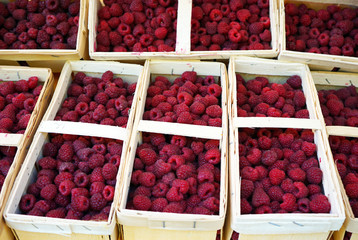 Wooden baskets with ripe raspberries on the counter of a street shop.