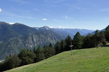 Fototapeta na wymiar A landscape of green mountains, with pines and firs, rocks and glaciers, in the Vigezzo Valley, northern Italian Alps