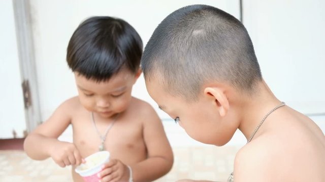 Two asian brothers enjoy eating ice-cream together