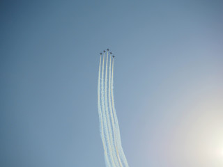 Reactive jet plane flying in formation and leave inversion trail on blue sky