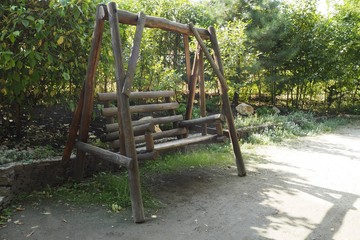 Fototapeta na wymiar wooden bench swing at the park