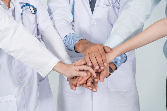 Close up doctor and nurse in a medical team stacking hands