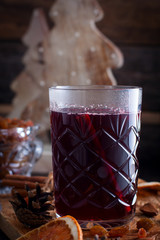 Scandinavian hot alcoholic drink with cinnamon in a glass cup on a wooden board, selective focus