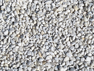 White pebbles background. Beach stones close-up, natural pattern