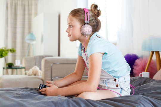 Cute Girl Playing Video Game In Her Bedroom