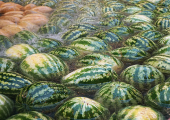 Fototapeta na wymiar Ripe fruits of watermelon and melon lie in the fountain of the shopping complex.